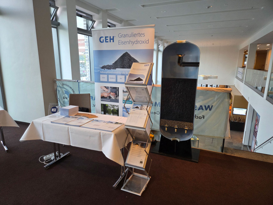 Messestand der Firma GEH Wasserchemie mit Banner, Broschürenständer, Tisch mit Infomaterialien und Filtermodell.